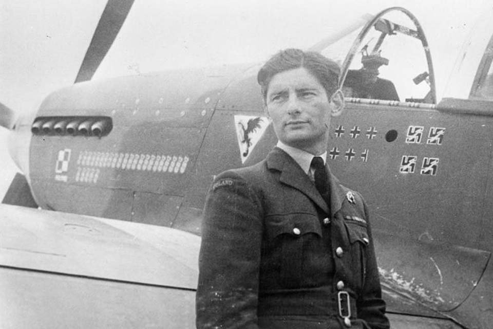 Squadron Leader Eugeniusz Horbaczewski of No. 315 Polish Fighter Squadron, standing by his new Mustang Mark III (FB387, PK-G) at Brenzett, Kent. The number of 'kills' of enemy planes is shown on the fuselage.