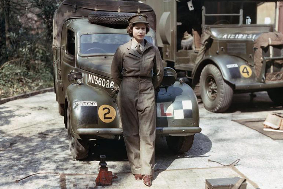 Princess Elizabeth, a 2nd Subaltern in the Auxiliary Territorial Service (ATS), wearing overalls and standing in front of an L-plated truck. 