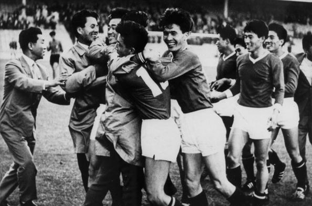 2 football teams (Italy and North Korea) members mixing and hugging each other after a match on the pitch
