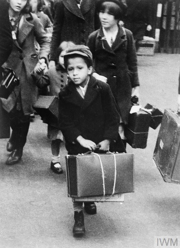 A small black boy carrying his luggage as he left London for the country with a party of other evacuees on 5 July 1940. 