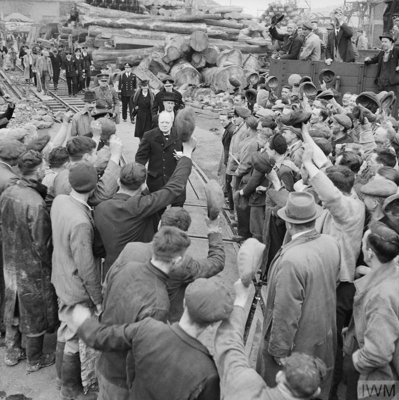 Surrounded by workers, Winston Churchill and Viscountess Astor is cheered by them during a visit to bomb-damaged.